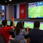 Fans cheering at a sports betting venue, 瞭解內容 around the excitement of live soccer matches.
